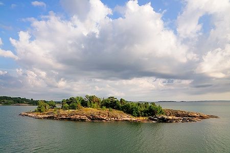 Isola con alberi e nuvole nel cielo nell'arcipelago delle Åland, Finlandia.