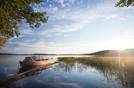 Barchetta da pesca ormeggiata sul lago Saimaa, illuminata dal sole del mattino.