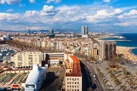 Panoramica di La Barceloneta a Barcellona con spiaggia, edifici e mare.