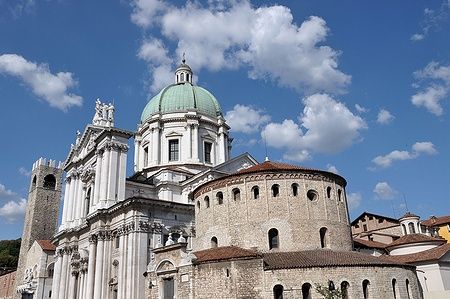 Facciata del Duomo Nuovo a Brescia con la sua cupola verde e cielo azzurro.