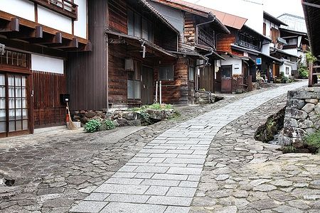 Strada lastricata nel villaggio di Magome, Giappone, con case tradizionali in legno.