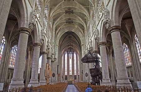 Interno della chiesa gotica Notre Dame du Sablon a Bruxelles con colonne e vetrate.