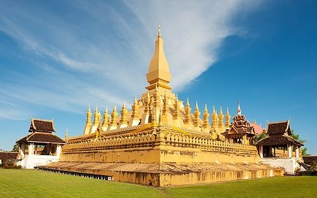 Pha That Luang stupa dorato a Vientiane, Laos sotto un cielo blu.
