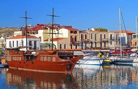 Porto veneziano di Rethymno a Creta con nave in legno e edifici storici.