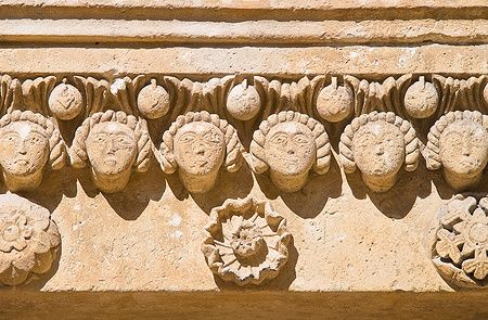 Dettaglio del rilievo sulla facciata della Cattedrale di Matera con volti scolpiti.