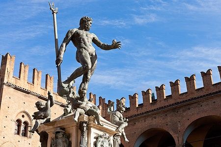 Statua del Nettuno sotto un cielo azzurro a Bologna.