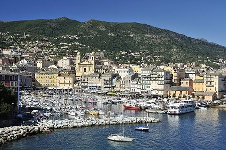 Vieux Port Marina a Bastia, Corsica, con barche ancorate e case colorate sullo sfondo.