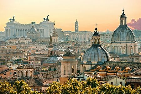 Vista di Roma da Castel Sant'Angelo al tramonto con cupole e monumenti storici.