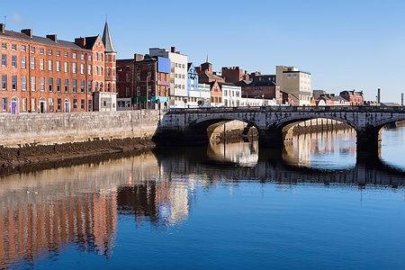 Edifici in mattoni lungo St Patrick's Quay a Cork City, riflessi nel fiume Lee.
