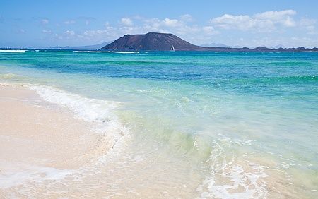 Acque cristalline di Corralejo Flag Beach con Isla de Lobos sullo sfondo.