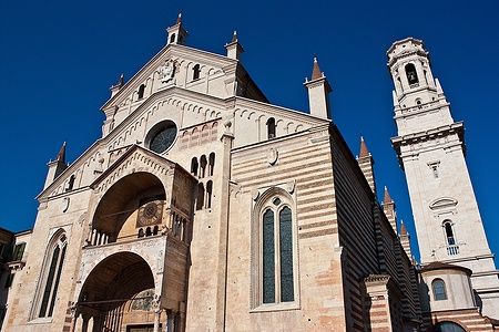 Facciata del Duomo di Verona in stile romanico sotto un cielo blu.