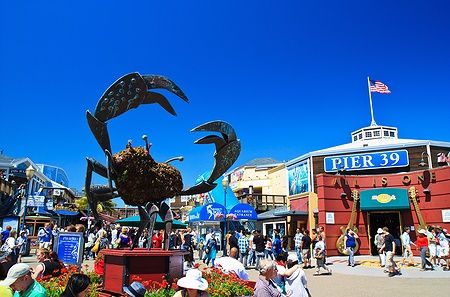 Pier 39 a Fisherman's Wharf, San Francisco, con la statua di un granchio e una folla di visitatori.