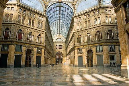 Interno della Galleria Umberto I a Napoli con dettagli architettonici e volte in vetro.
