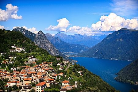 Vista panoramica di Lugano e il Lago di Lugano con montagne sullo sfondo.