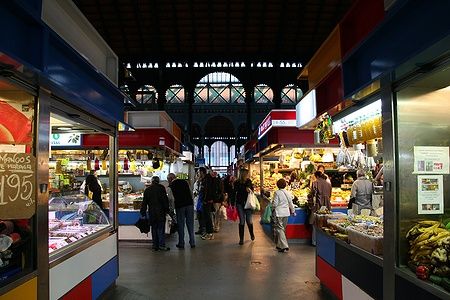 Interno del mercato coperto Atarazanas a Malaga con bancarelle e persone.