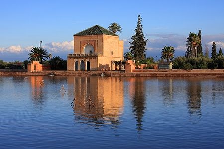 Padiglione Menara di Marrakech riflesso su un lago al tramonto.