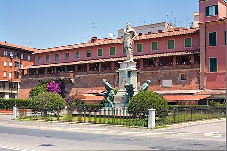 Monumento dei Quattro Mori a Livorno con edifici colorati sullo sfondo.