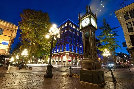 Orologio a vapore a Gastown, Vancouver, con edifici storici illuminati di sera.