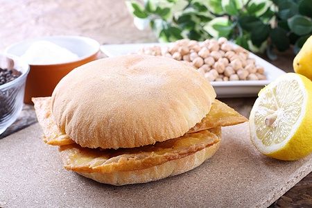 Panino con panelle, limone e ceci su uno sfondo complesso.