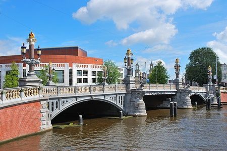 Il ponte blu di Amsterdam sopra il fiume Amstel con la Stopera sullo sfondo.