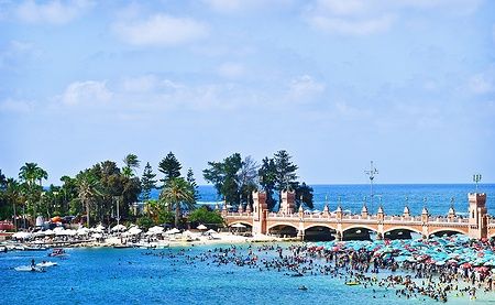 Spiaggia affollata con ombrelloni colorati ad Alessandria, Egitto, sul Mar Mediterraneo.