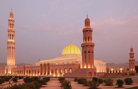 Sultan Qaboos Grand Mosque a Muscat illuminata al tramonto.