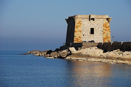 Torre di Ligny a Trapani circondata dal mare con cielo limpido.