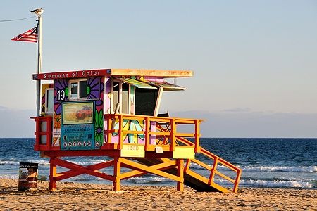 Torretta da bagnino colorata su Venice Beach, Los Angeles, con l'oceano sullo sfondo.