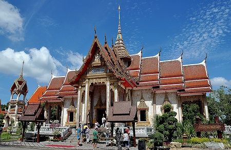 Ubosot del Wat Chalong a Phuket con tetti a più livelli e guglia dorata.
