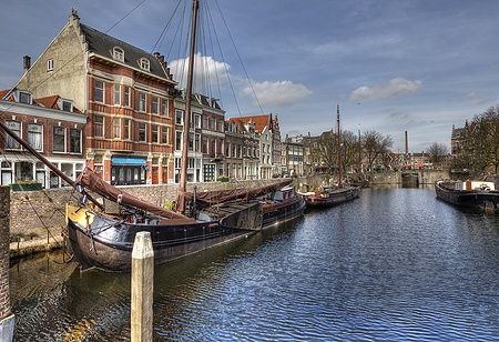 Barche storiche lungo il canale a Delfshaven, Rotterdam, con edifici tradizionali.