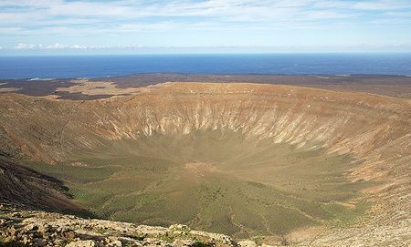 Cratere del vulcano Montana Blanca a Lanzarote con oceano sullo sfondo.