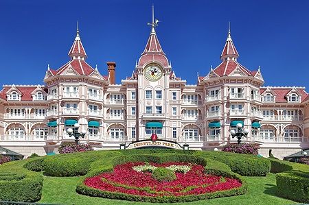 Entrata del Disneyland Park a Parigi con edificio iconico e aiuola fiorita.