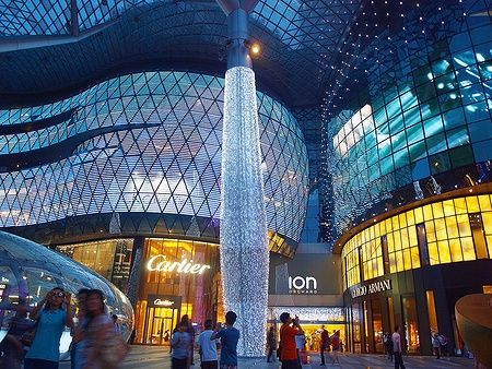 ION Orchard illuminato di notte con persone e luci scintillanti.