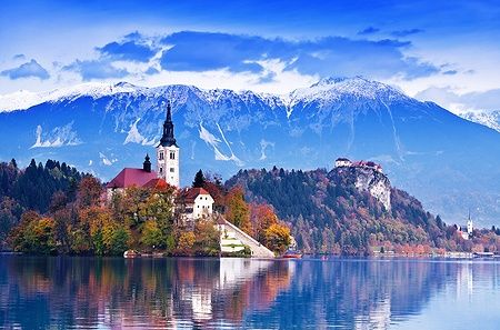 Il lago di Bled con isola, chiesa, castello e montagne innevate.