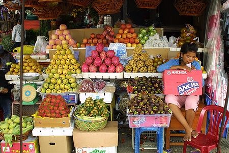 Donna vende frutta in un mercato all'aperto a Phnom Penh.