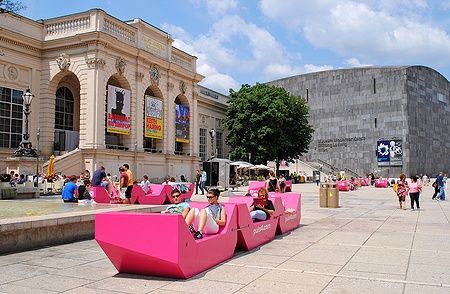 Persone su sedute rosa davanti al Kunsthalle Wien nel Museum Quarter di Vienna.