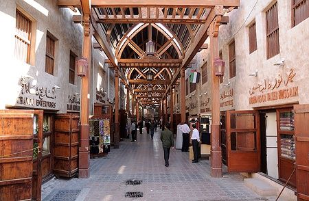 Il vecchio souk di Dubai con negozi e persone che passeggiano.