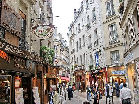 Strada del Quartier Latin a Parigi con ristoranti e passanti.