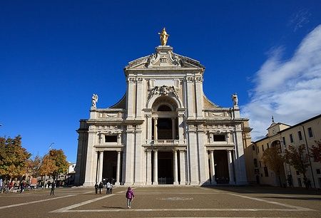 Facciata della Basilica di Santa Maria degli Angeli ad Assisi con persone in piazza.