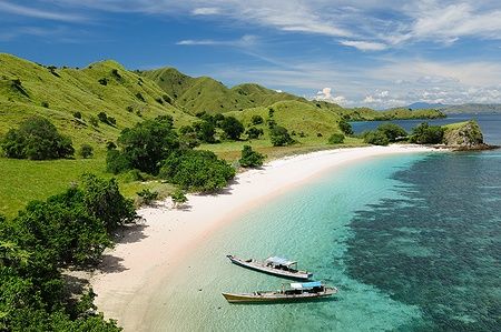 Spiaggia con sabbia bianca e barche nel Parco Nazionale di Komodo, Indonesia.