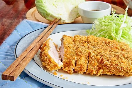 Tonkatsu giapponese con cavolo e salsa su un piatto