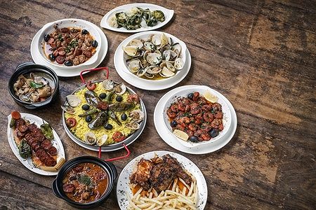Selezione di tapas portoghesi tradizionali su un tavolo di legno.