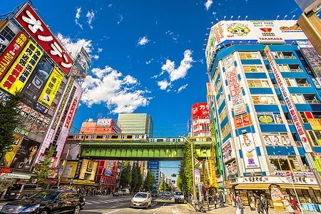Strada di Akihabara a Tokyo con treno su ponte e edifici colorati.