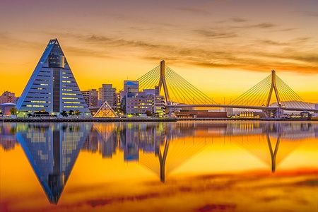 Skyline di Aomori City al tramonto con riflessi sull'acqua.
