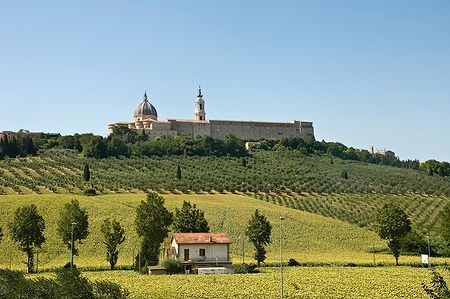 Vista della Basilica della Santa Casa a Loreto con campi e alberi.