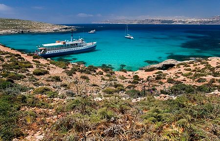 La Blue Lagoon a Comino, Malta, con acque turchesi e barche.