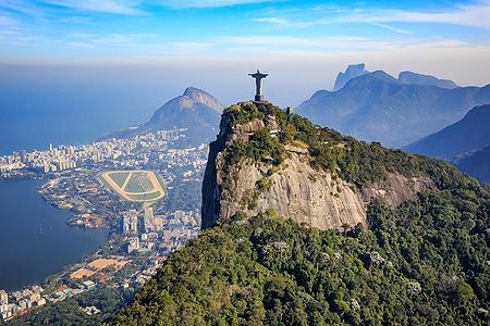 Veduta aerea del Cristo Redentore sopra Rio de Janeiro e montagne circostanti.