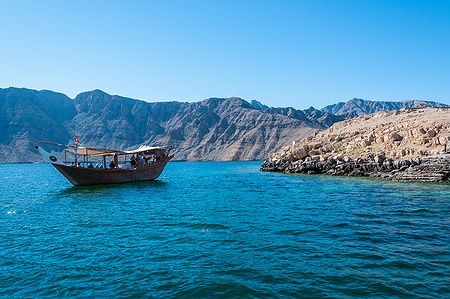 Dhow nel Golfo di Oman con montagne di Musandam sullo sfondo.