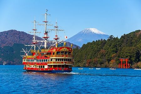 Nave sul lago Ashi con il Monte Fuji e un torii rosso sullo sfondo.
