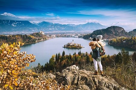 Famiglia guarda il lago di Bled con isola e chiesa in Slovenia, paesaggio montano.